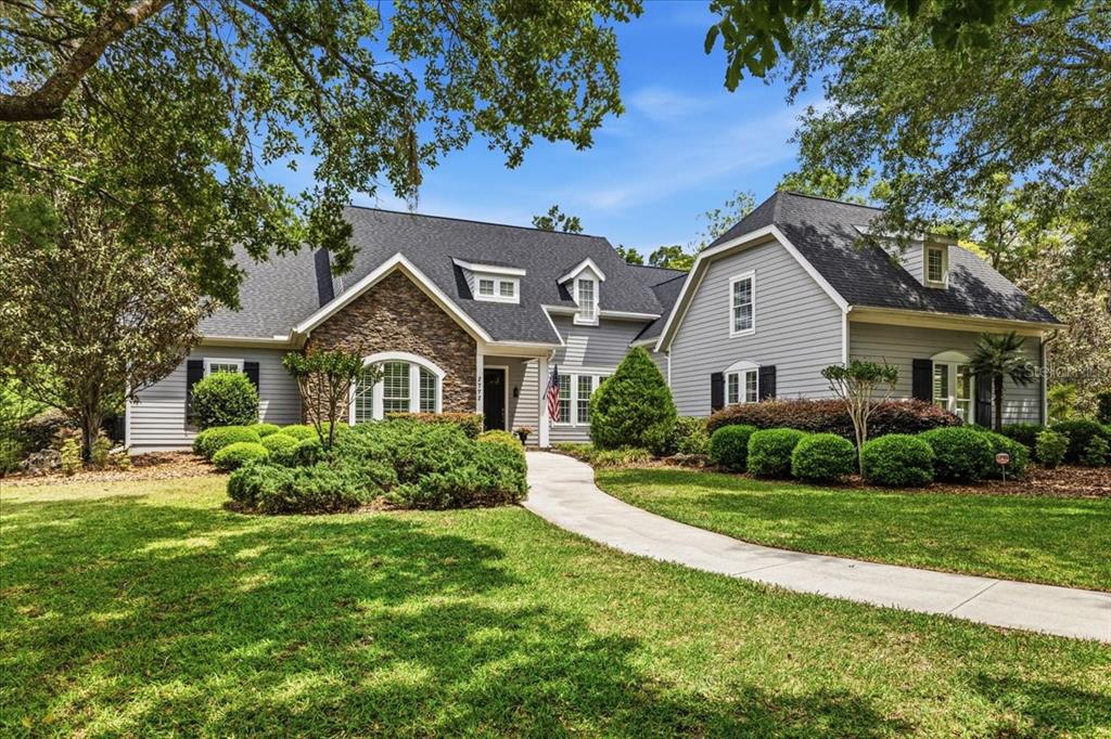 A two-story house with gray siding, a stone facade, and a paved walkway — 2772 NW 26TH PLACE, GAINESVILLE, FL