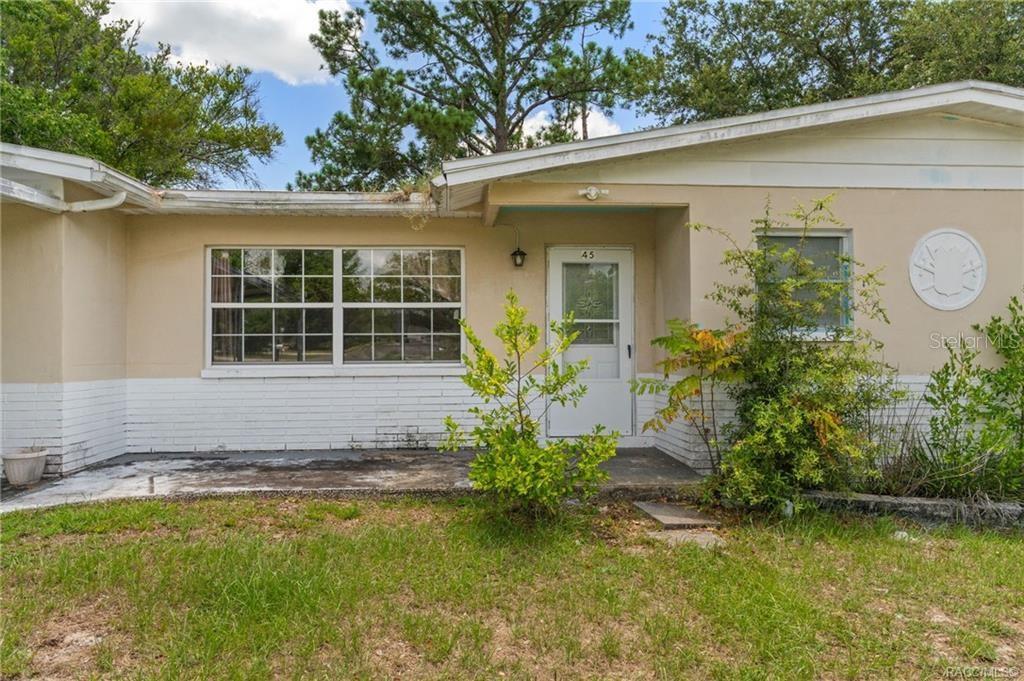 A single-story house exterior with a white brick base, beige siding, and a front porch — 45 S BARBOUR STREET, BEVERLY HILLS, FL