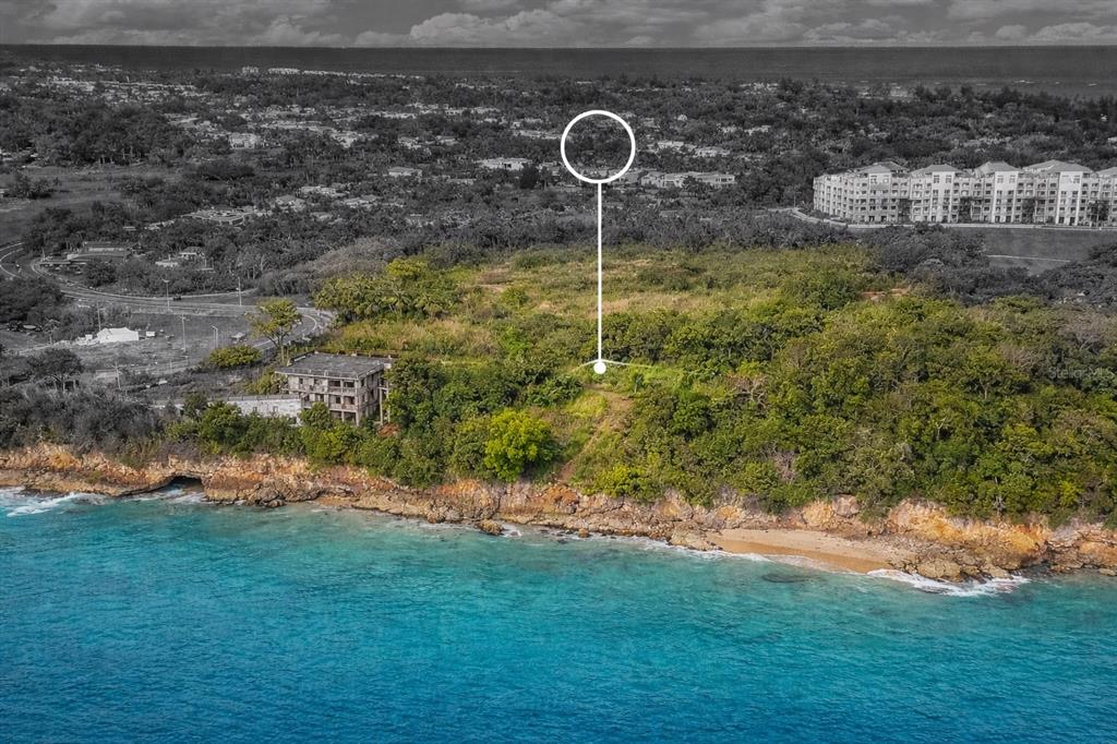 An aerial view shows a coastal plot of land with a partially constructed building nearby — CARR 107 KM 1.1 BO BORINQUEN, AGUADILLA, PR