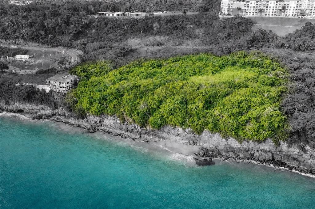 An aerial view shows a lush green coastal plot of land bordering a rocky shoreline — CARR 107 KM 1.1 BO BORINQUEN, AGUADILLA, PR