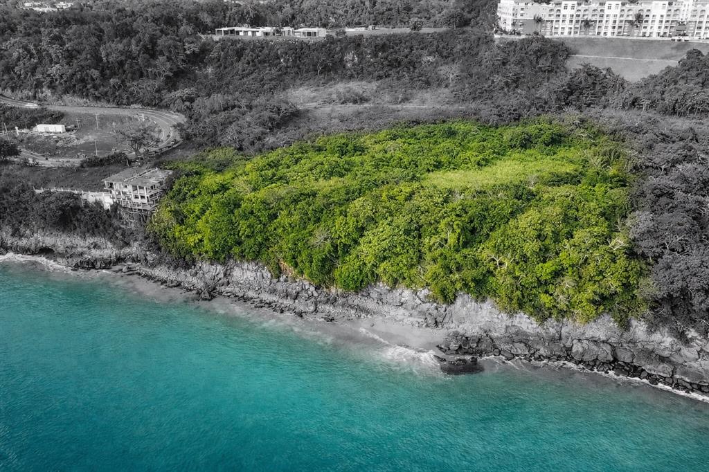 An aerial view shows a lush green coastal lot situated above a rocky shoreline — CARR 107 KM 1.1 BO BORINQUEN, AGUADILLA, PR