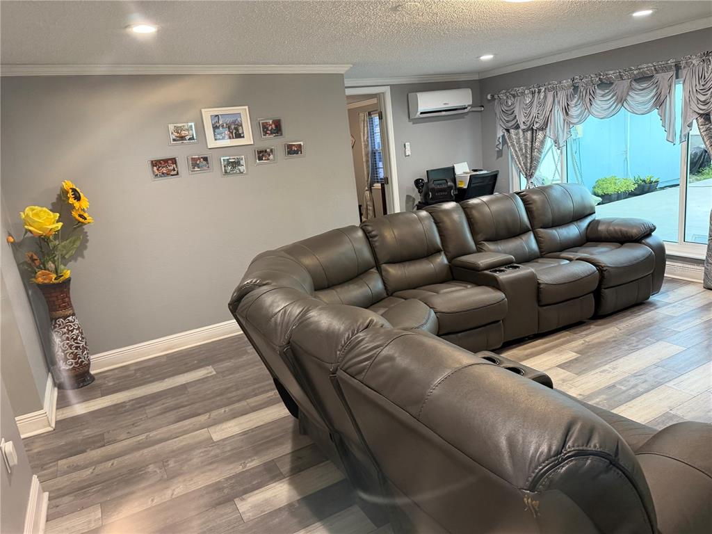 A living room features gray walls, wood-look flooring, a large sectional sofa, and a window — 4519 EDEN ROCK ROAD, TAMPA, FL