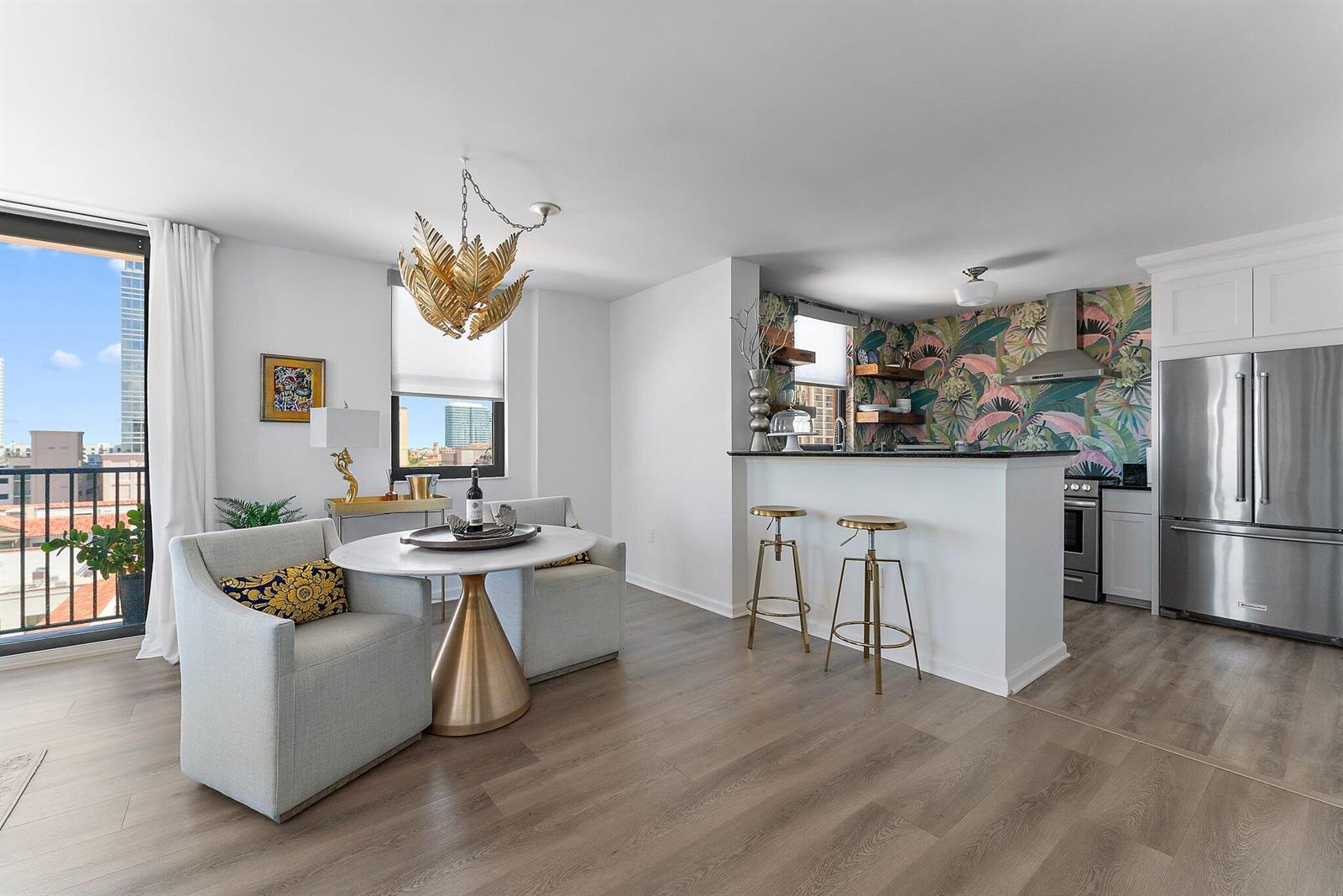 A kitchen and dining area with a breakfast bar, patterned wallpaper, and a balcony view — 651 Okeechobee Boulevard # 612, West Palm Beach FL 33401, WEST PALM BEACH, FL