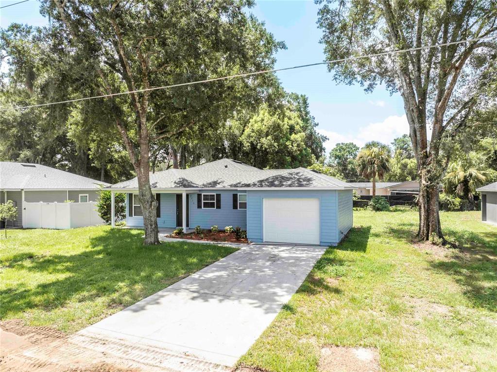 A light blue single-story house with a white garage door and a concrete driveway — 2270 SUANEE AVENUE, EUSTIS, FL