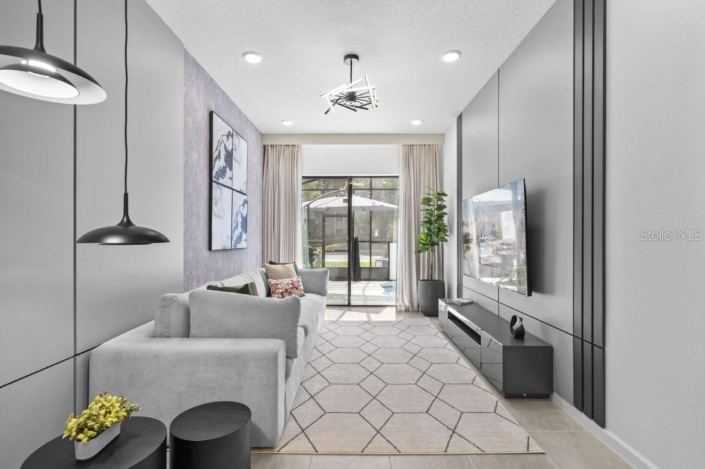 A modern living room features a gray sofa, a wall-mounted television, and a geometric rug — 10424 EBB TIDE LANE, ORLANDO, FL