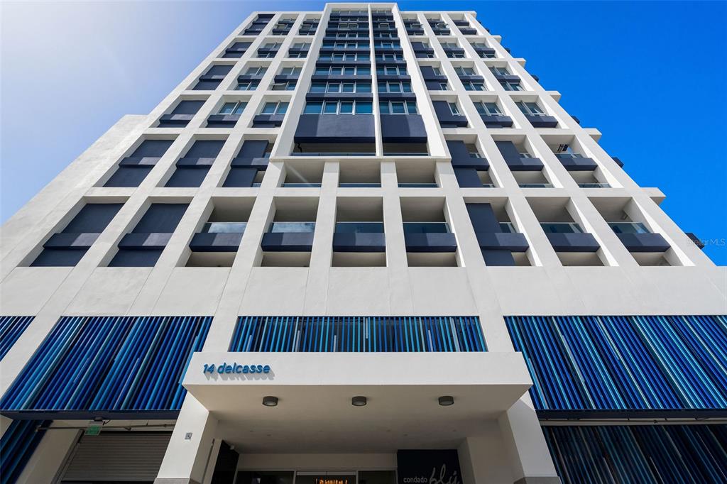 A low-angle view of a modern white high-rise building with blue accents and balconies — Condado Blu 14 DELCASSE ST, CONDADO UNIT 802, SAN JUAN, PR