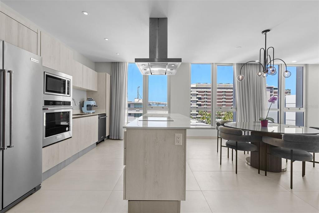 A modern kitchen features light wood cabinetry, a central island, and a dining area — Condado Blu 14 DELCASSE ST, CONDADO UNIT 802, SAN JUAN, PR