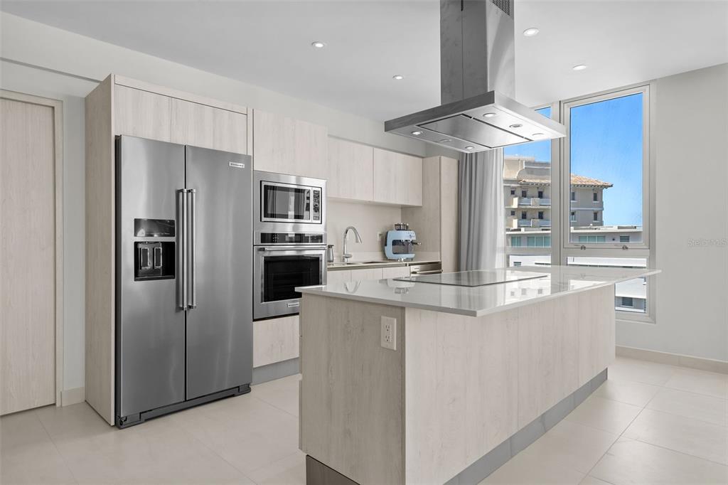 A modern kitchen features light wood cabinetry, stainless steel appliances, and a central island — Condado Blu 14 DELCASSE ST, CONDADO UNIT 802, SAN JUAN, PR