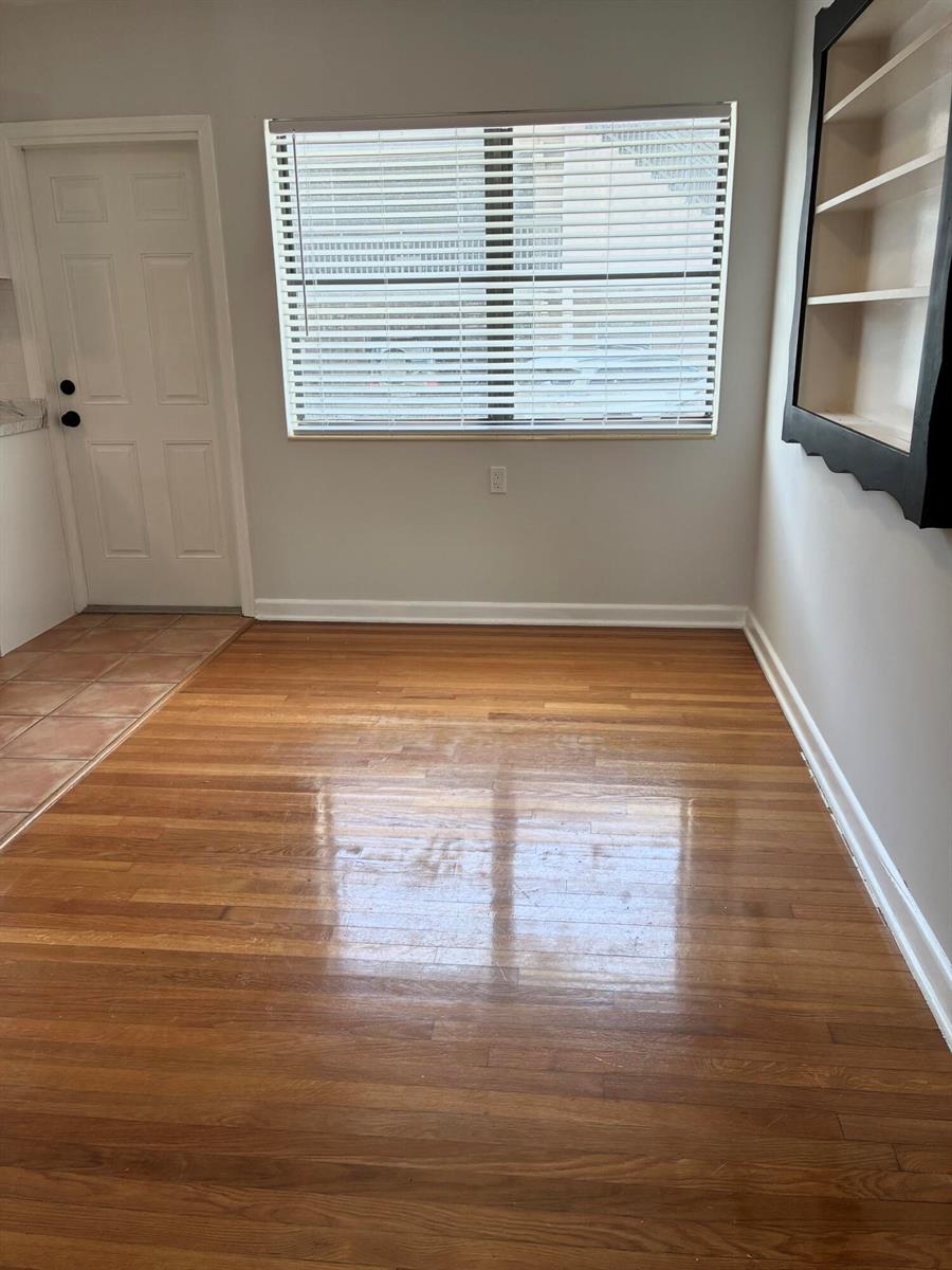 An empty room features hardwood floors, a window with blinds, and a built-in wall shelf — 130 S Lakeside Drive # 1, FL 33460, FL