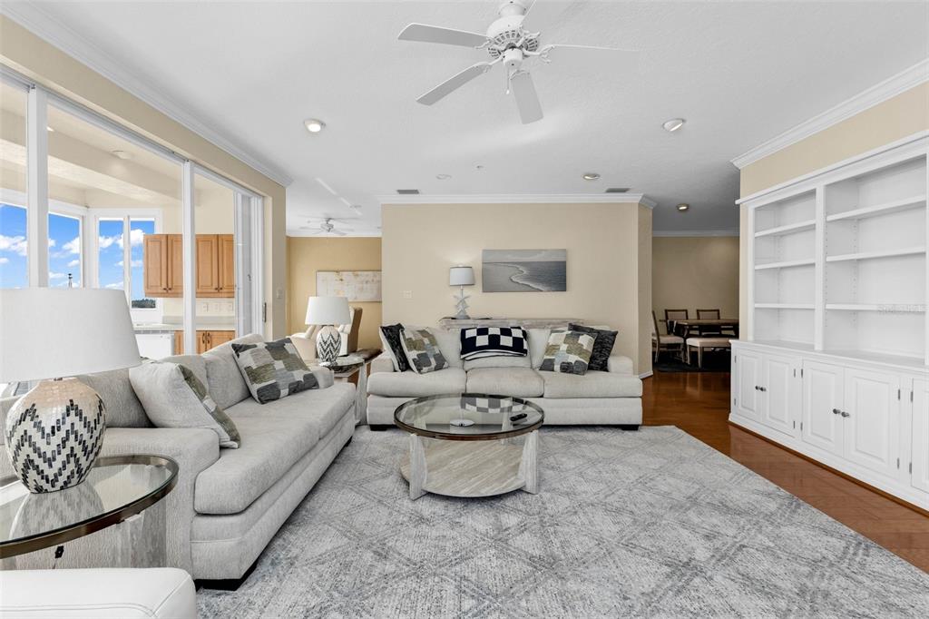 A living room features light-colored sofas, a glass coffee table, and white built-in shelving — 200 HARBOR WALK DRIVE UNIT 251, PUNTA GORDA, FL