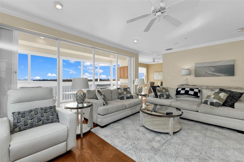 A living room with light-colored sofas, a glass coffee table, and a view of water — 200 HARBOR WALK DRIVE UNIT 251, PUNTA GORDA, FL