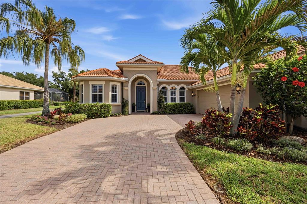 A single-story house with a tiled roof, arched entryway, and a paved driveway — 170 MONTELLUNA DRIVE, NORTH VENICE, FL