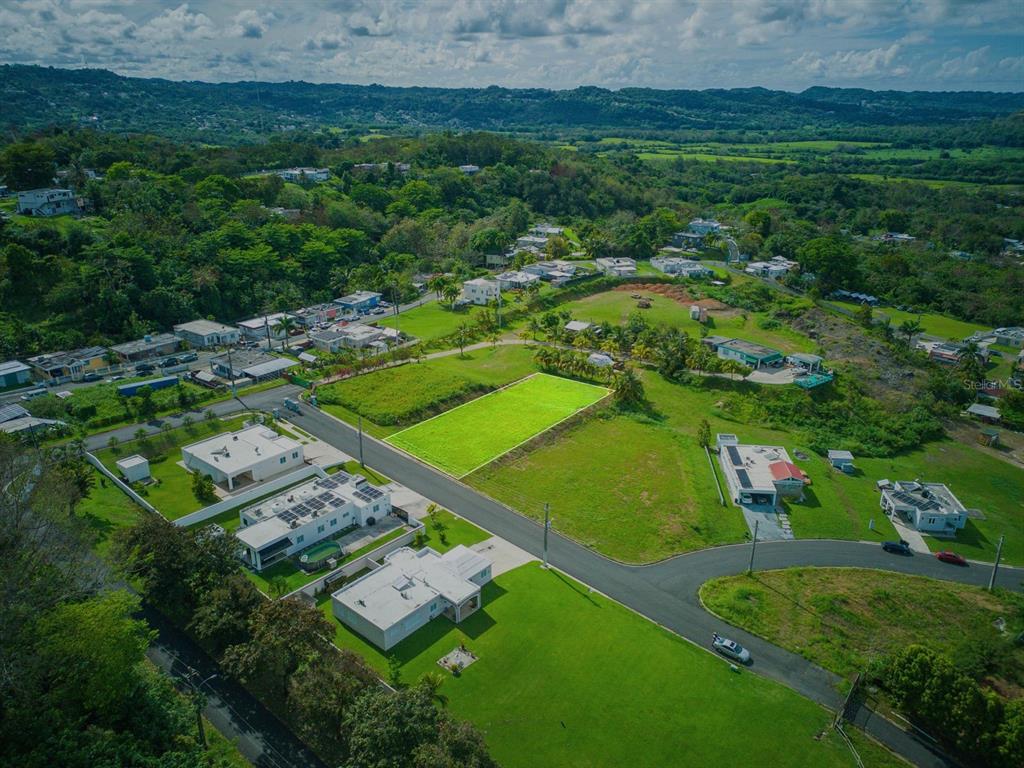 An aerial view shows a vacant rectangular plot of land highlighted in green within a neighborhood — E-2 S CALLE REINA MORA, TOA ALTA, PR