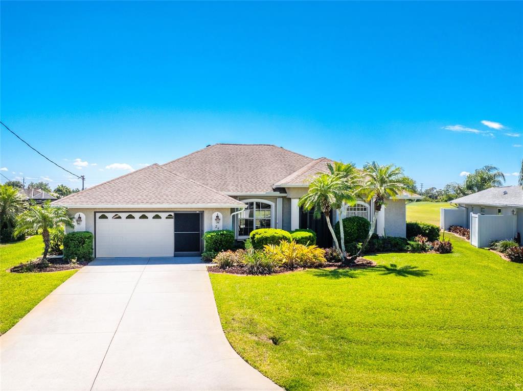 A single-story suburban house features a two-car garage, a concrete driveway, and landscaped front gardens — 28 MEDALIST COURT, ROTONDA WEST, FL