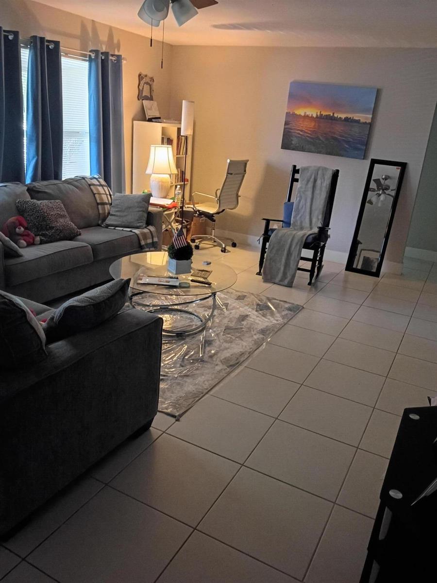 A living room features gray sofas, a glass coffee table, a desk, and tile flooring — 1270 NW 66th Terrace, Margate FL 33063, MARGATE, FL