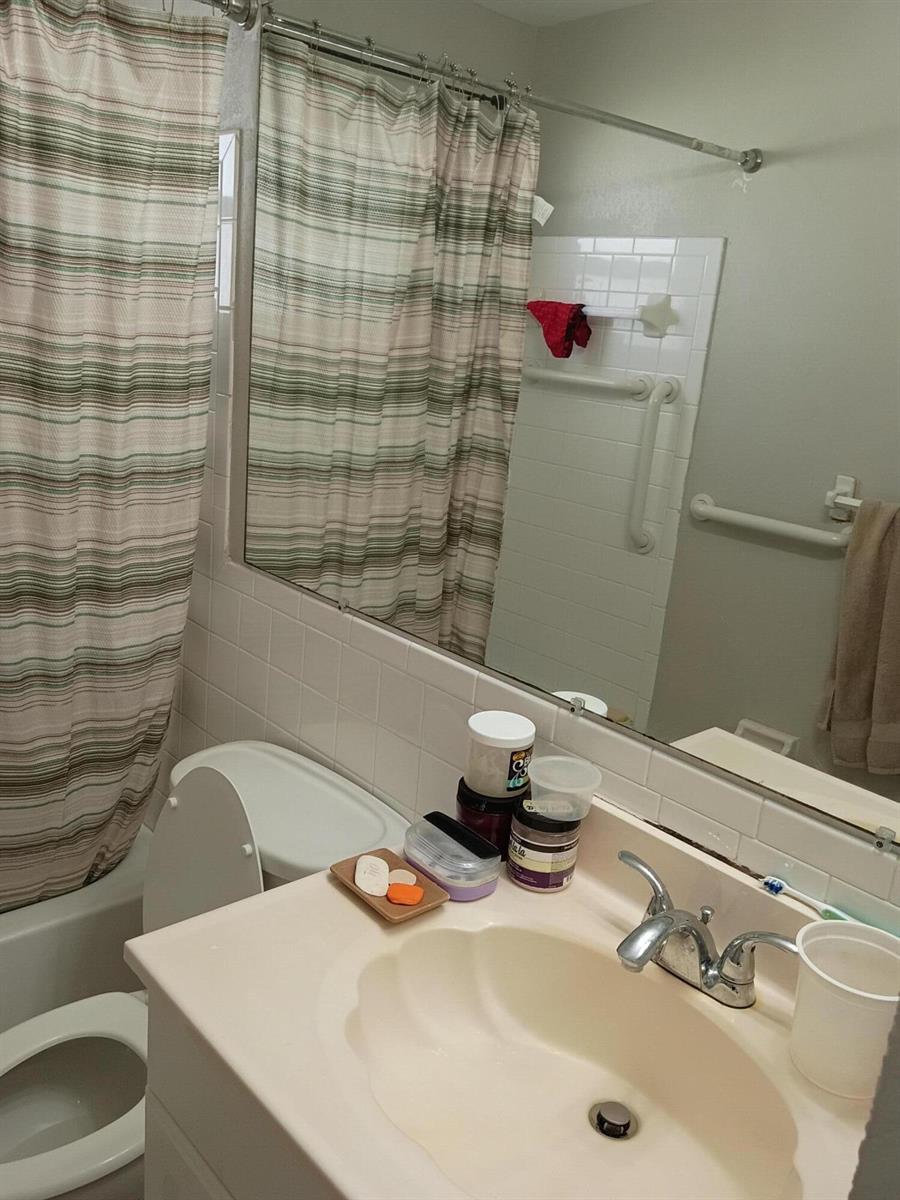 A bathroom features a vanity with a sink, a toilet, and a shower with curtains — 1270 NW 66th Terrace, Margate FL 33063, MARGATE, FL