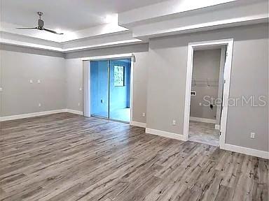 An interior room features light gray walls, wood-look flooring, a tray ceiling, and sliding doors — 52 ETHAN ALLEN DRIVE, PALM COAST, FL