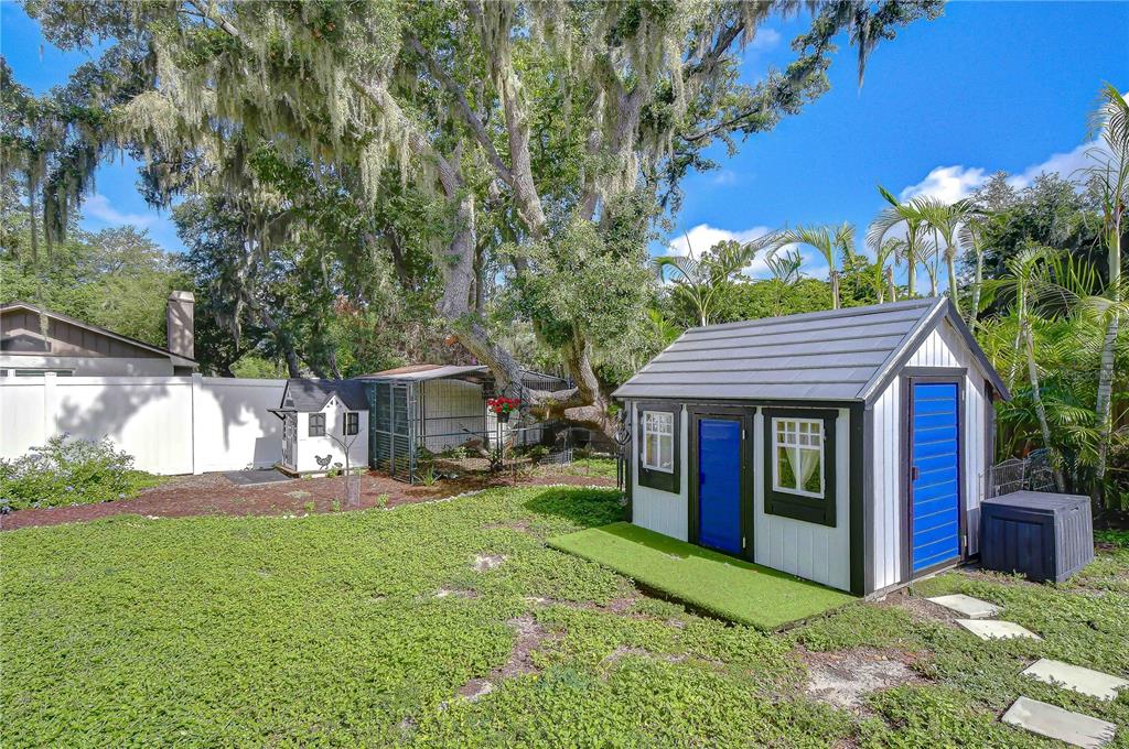 A rectangular swimming pool with a central spa sits on a paved patio near trees — 106 BAYFIELD DRIVE, BRANDON, FL