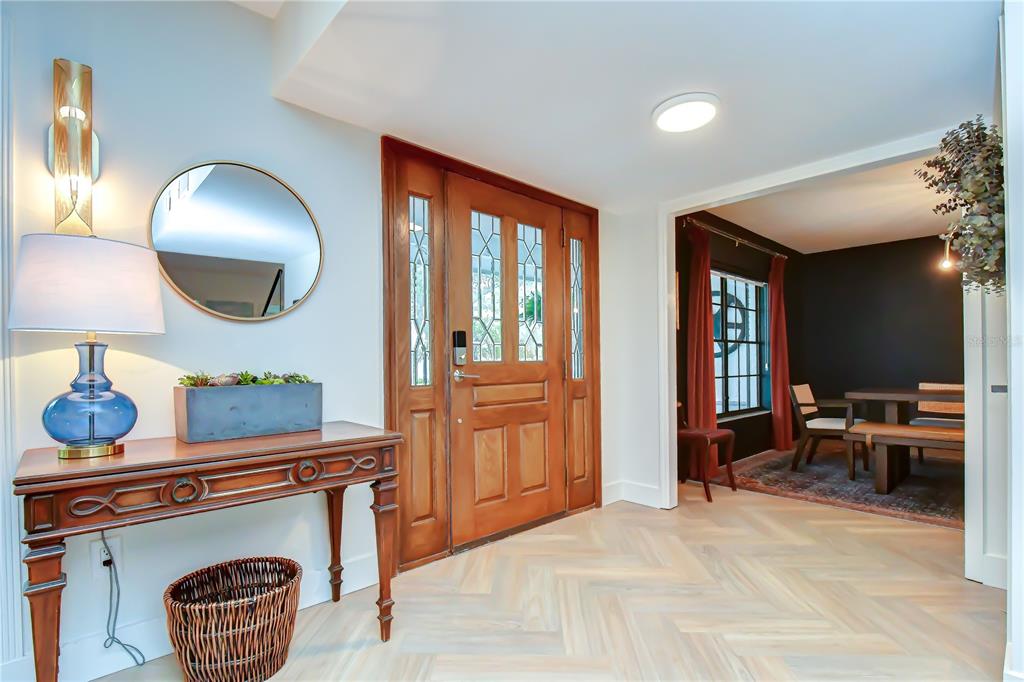 A backyard features a small playhouse, a larger shed with blue doors, and mature trees — 106 BAYFIELD DRIVE, BRANDON, FL