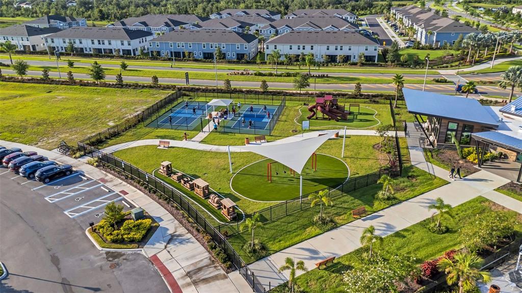 An aerial view shows a community park with pickleball courts, a playground, and parking — 5841 RIVERSTON AVENUE, WESLEY CHAPEL, FL