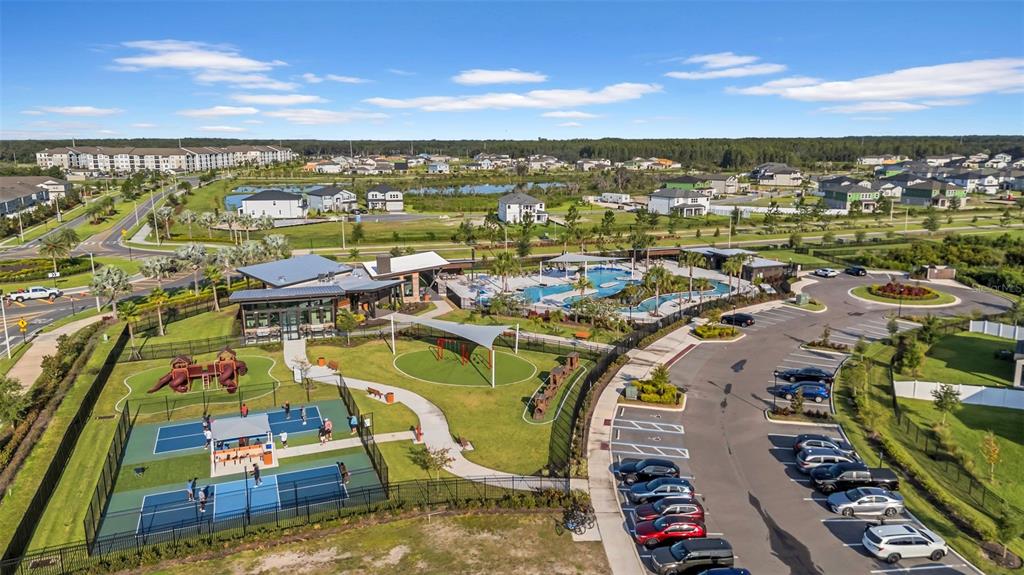An aerial view shows a community pool, playground, pickleball courts, and a parking lot — 5841 RIVERSTON AVENUE, WESLEY CHAPEL, FL
