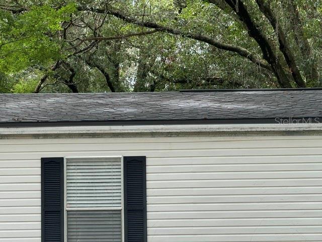 A close-up view shows the exterior siding, a window with black shutters, and a shingled roof — 6633 GLEN MEADOW LOOP, LAKELAND, FL