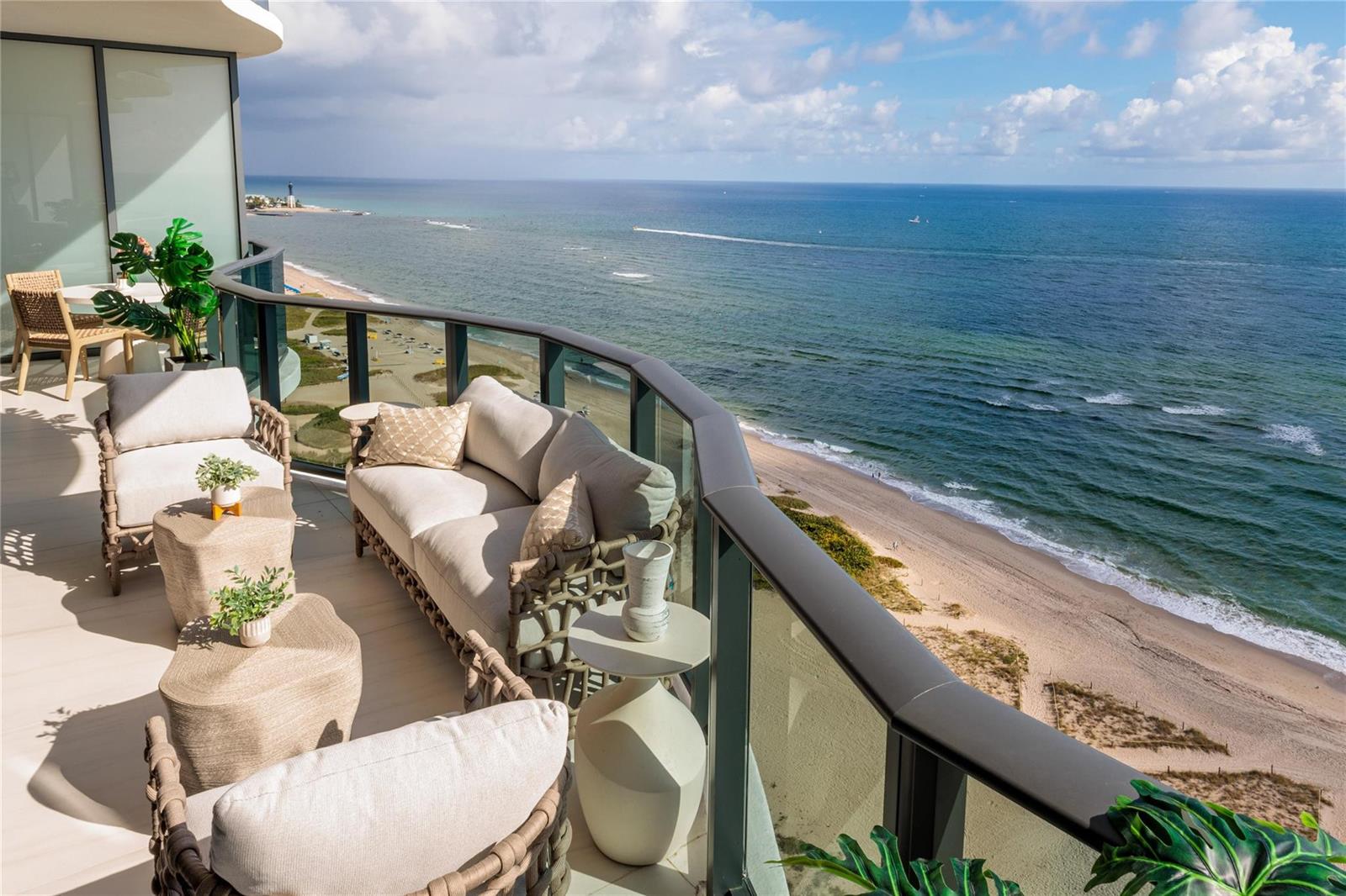 A balcony with outdoor seating overlooks a sandy beach and the ocean — 900 N Ocean Boulevard, Pompano Beach FL 33062, POMPANO BEACH, FL