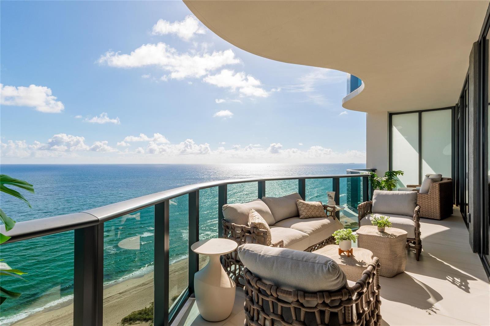 A balcony with outdoor furniture overlooks the ocean and a sandy beach — 900 N Ocean Boulevard, Pompano Beach FL 33062, POMPANO BEACH, FL