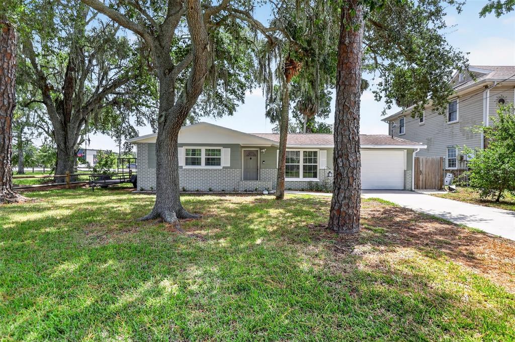 A single-story house with a gray brick facade, white trim, and an attached garage — 7212 WEDGEWOOD DRIVE, NEW PORT RICHEY, FL