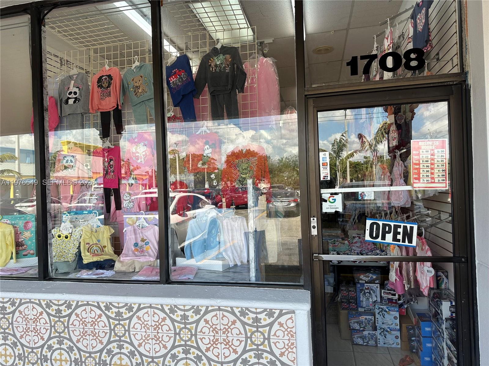 The exterior of a retail storefront features a glass display window filled with children's clothing — 1708 W 68 Street, Hialeah FL 33014, HIALEAH, FL