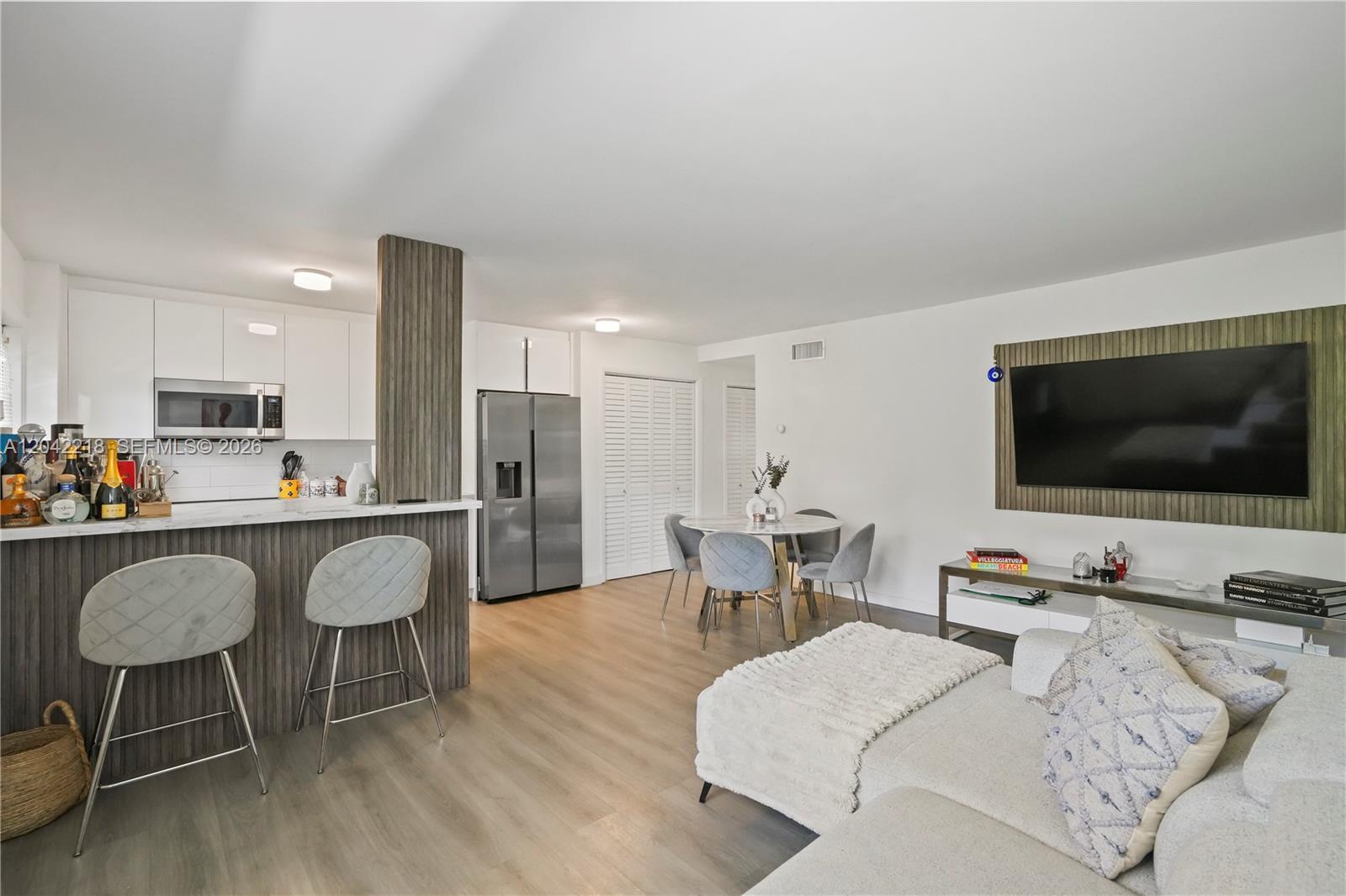 An open-concept living area features a kitchen with a breakfast bar and dining space — 1614 West Ave # 203, Miami Beach FL 33139, MIAMI BEACH, FL