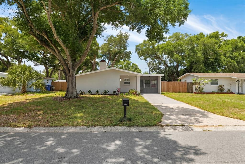 A single-story house with a white exterior, a concrete driveway, and a large front tree — 2952 WEBLEY DRIVE, LARGO, FL