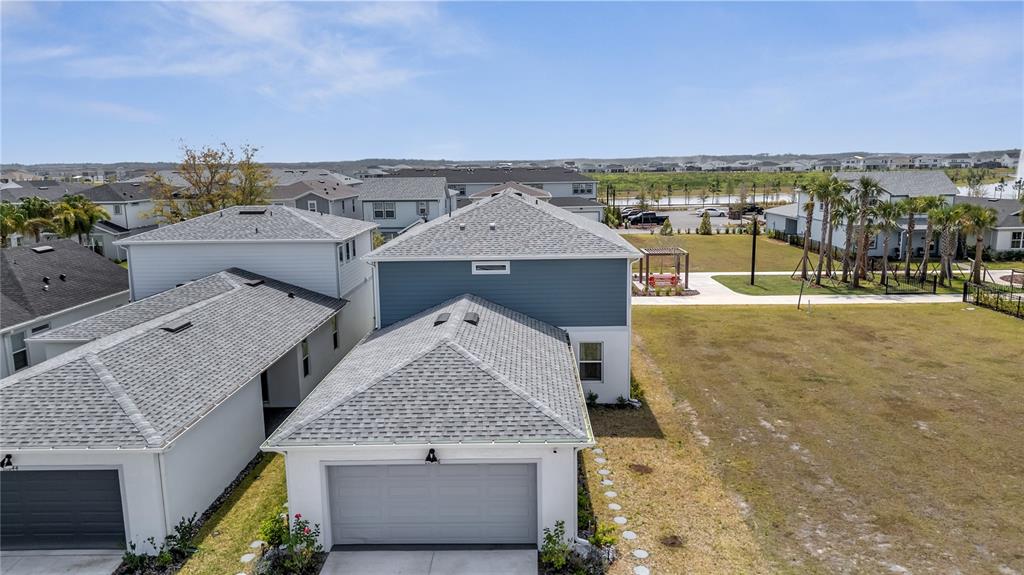 An aerial view shows the exterior of two adjacent suburban houses with gray roofs — 10836 WATERWOOD ALLEY, ORLANDO, FL