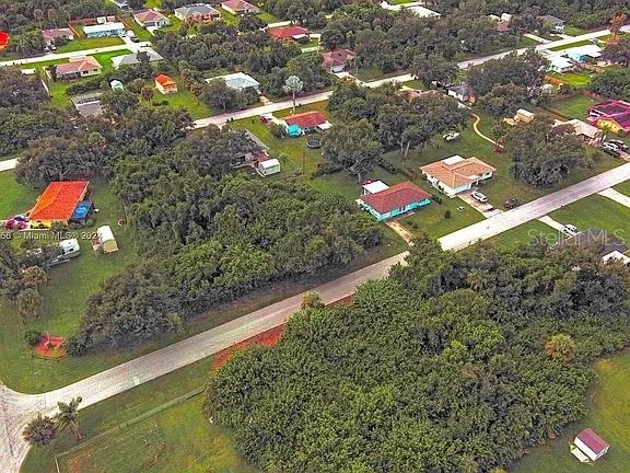 An aerial view shows a residential neighborhood with houses, trees, and paved roads — 21511 CARLETON AVENUE, PORT CHARLOTTE, FL