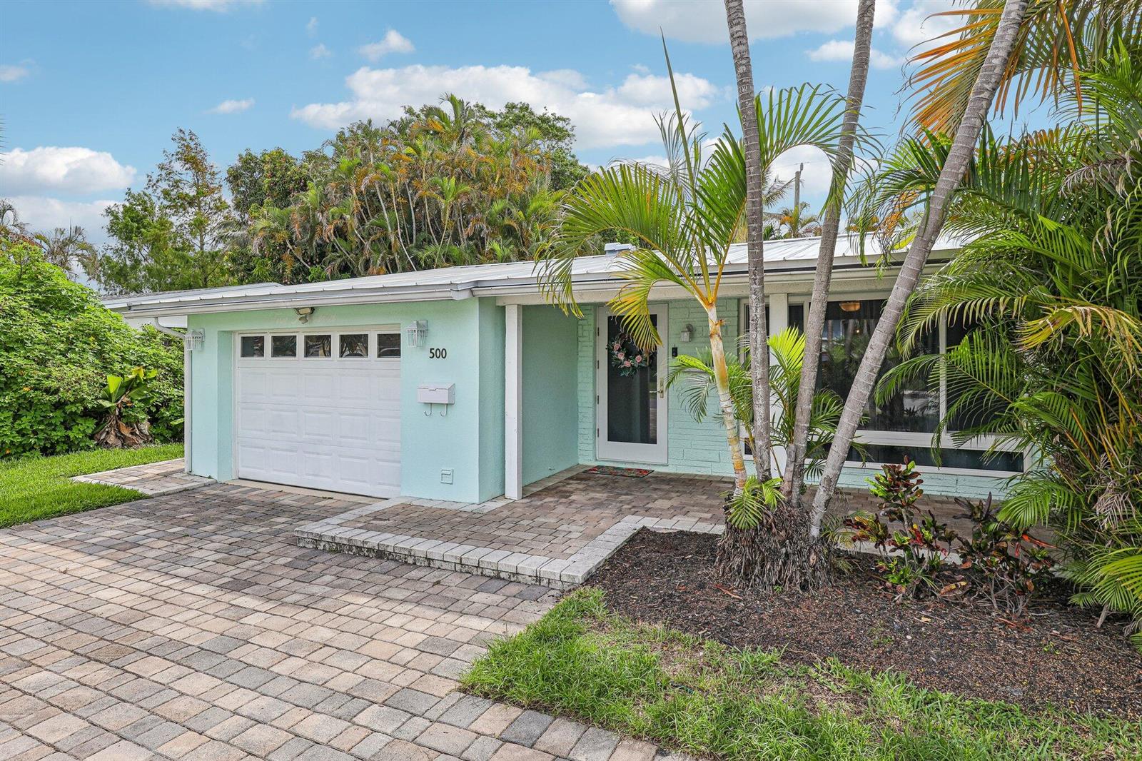 A light green single-story house features a paved driveway, a garage, and palm trees — 500 SE 8th Avenue, Deerfield Beach FL 33441, DEERFIELD BEACH, FL