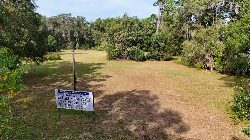 A sign for a future church stands on a large, grassy, wooded lot — 2495 NW NW 21ST STREET, OCALA, FL