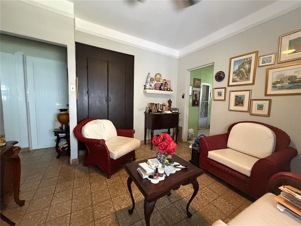 A living room features red wicker furniture, a dark wood coffee table, and tiled floors — 559 CALLE AUSTRAL, SAN JUAN, PR