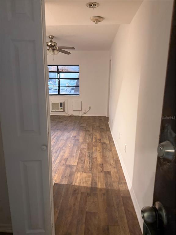 An interior view shows a room with wood-look flooring, a ceiling fan, and a window — 1264 113TH AVENUE UNIT J102, TAMPA, FL
