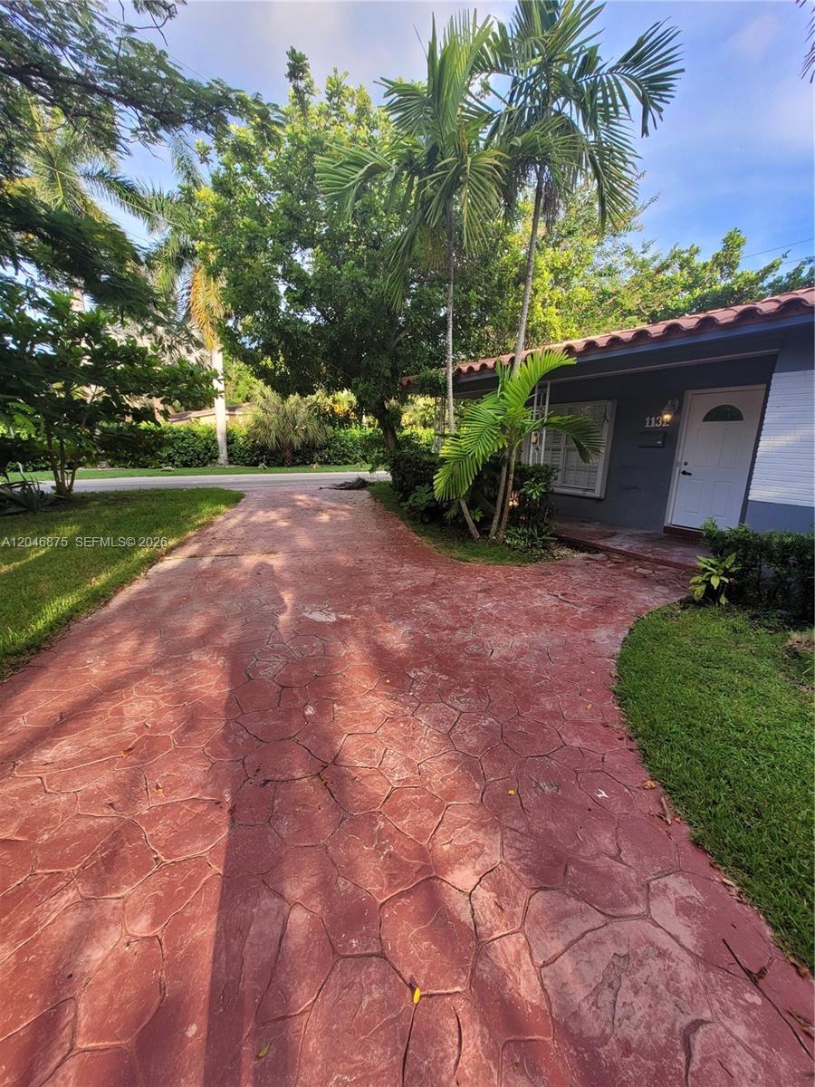 A red stamped concrete driveway leads to the front entrance of a single-story house — 1132 Moffett St, Hallandale Beach FL 33009, HALLANDALE BEACH, FL