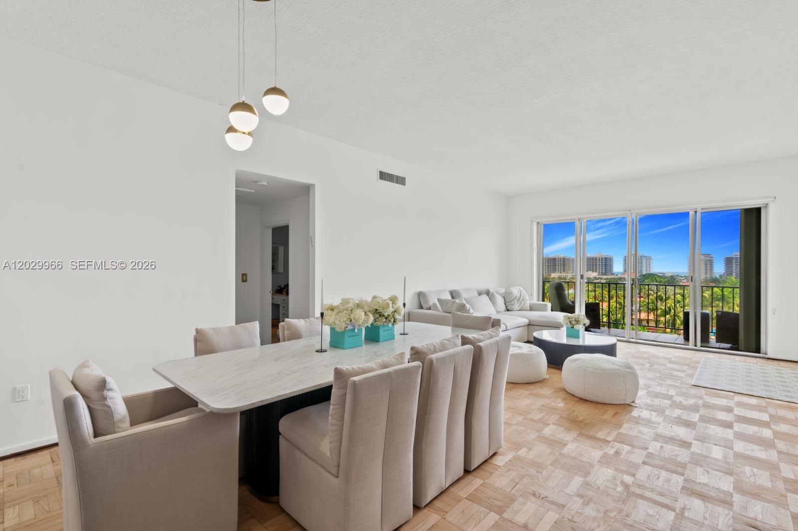 A dining and living area features a marble table, light-colored furniture, and parquet wood flooring — 9341 E Bay Harbor Dr # B, Bay Harbor Islands FL 33154, BAY HARBOR ISLANDS, FL