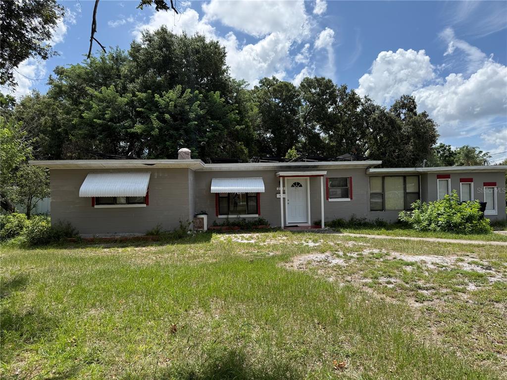 A single-story gray house with a flat roof, white awnings, and a front entrance — 203 LANTANA DRIVE, ORLANDO, FL