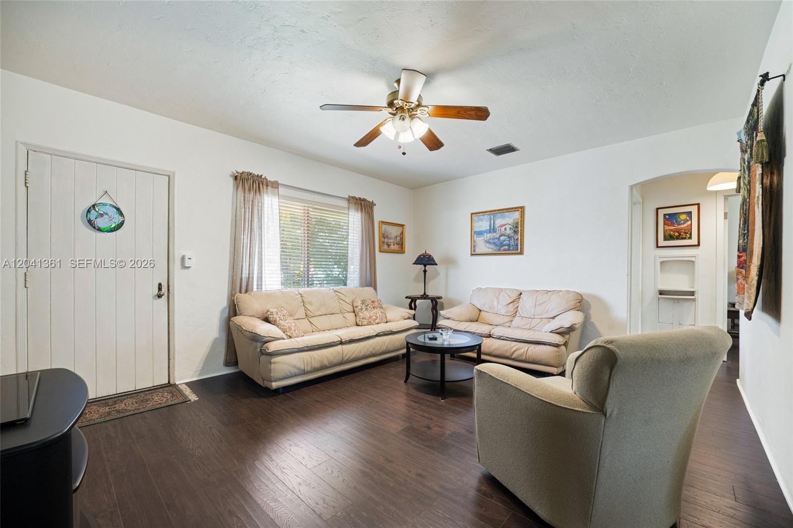 A living room features dark wood flooring, two cream sofas, and a ceiling fan — 2750 NW 4th St, Miami FL 33125, MIAMI, FL