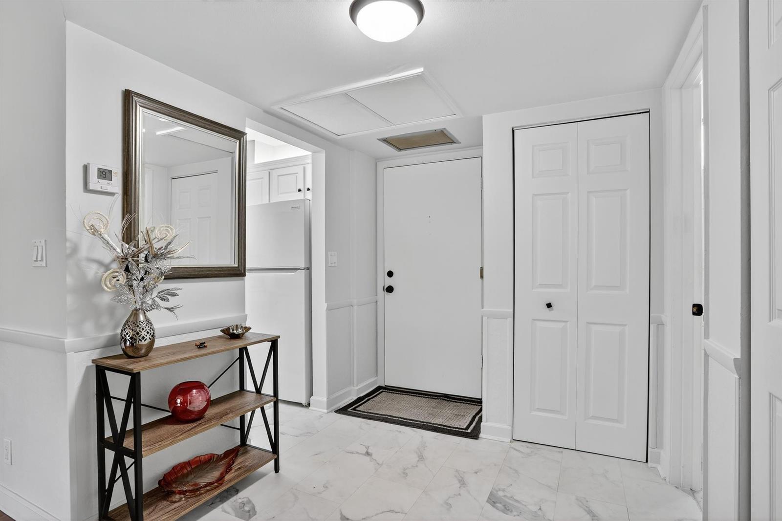 A bright entryway features white walls, marble-look tile flooring, a console table, and a closet — 5640 SW 3rd Place # 208, Margate FL 33068, MARGATE, FL