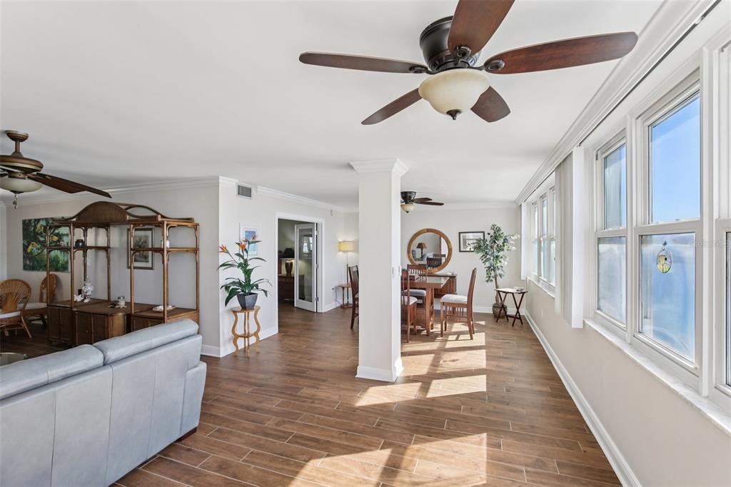 A living and dining area features wood-look tile flooring, white walls, and multiple ceiling fans — 5108 BRITTANY DRIVE S UNIT 805, ST PETERSBURG, FL