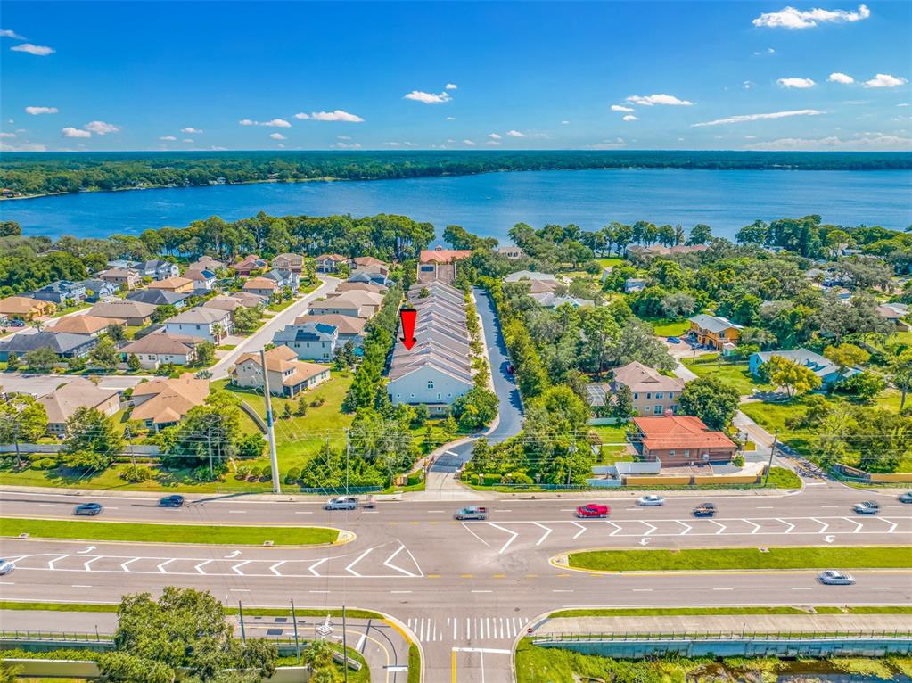 An aerial view shows a row of townhouses near a large lake and road — 1425 HILLSIDE LANDING DRIVE, TARPON SPRINGS, FL