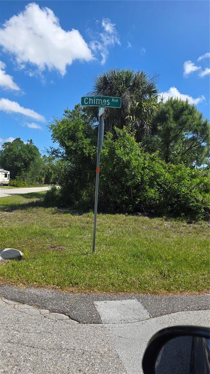 A street sign for Chimes Ave stands in a grassy area with trees and blue skies — 23445 CHIMES AVENUE, PUNTA GORDA, FL