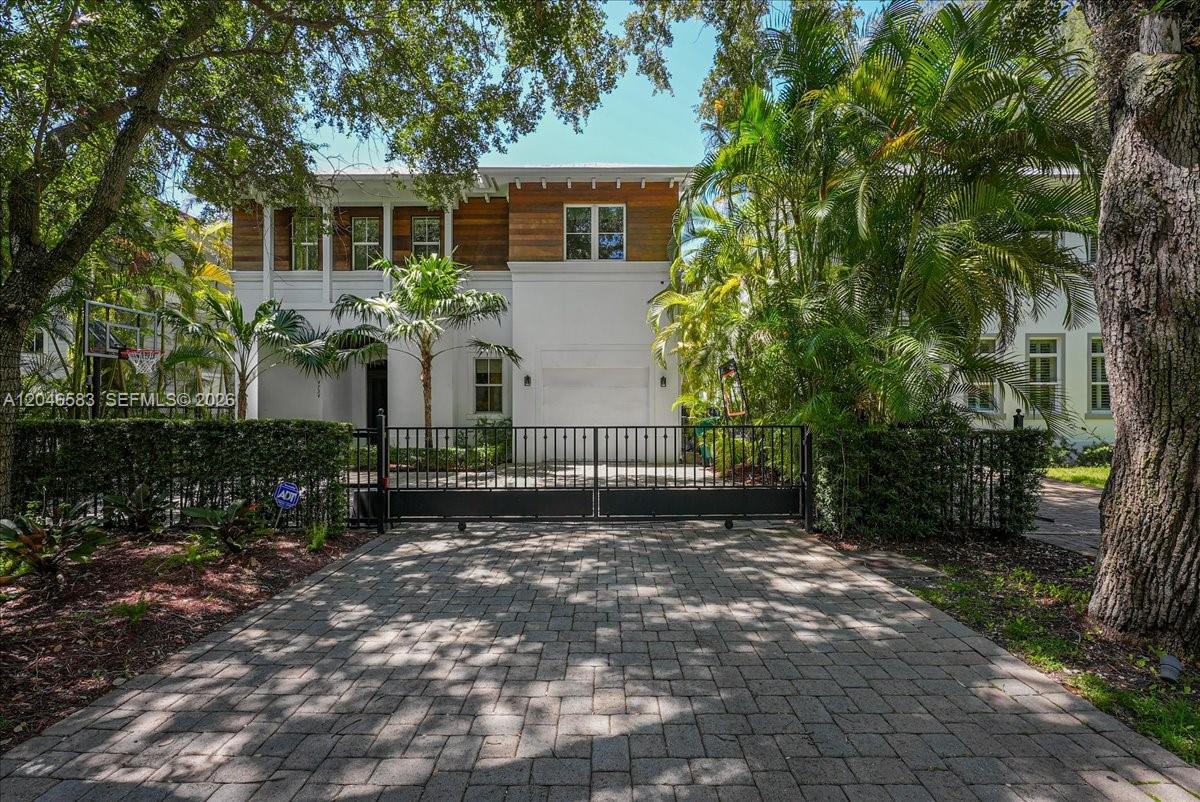 A two-story house with white stucco, wood siding, and a gated paver driveway — 4734 Sunset Drive, Miami FL 33143, MIAMI, FL