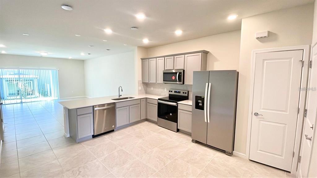 A kitchen with light gray cabinets, stainless steel appliances, and tile flooring — 2571 WINSOME WAY, DAVENPORT, FL