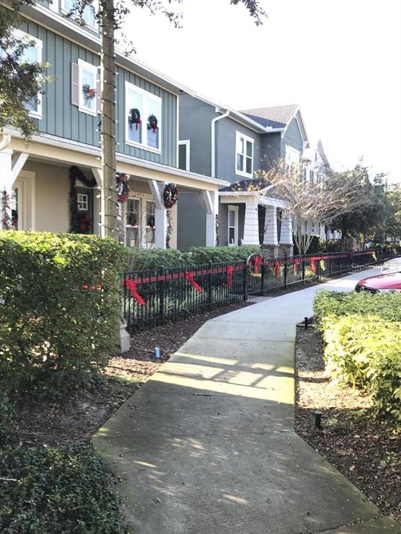 A sidewalk leads past a row of townhouses decorated with Christmas wreaths and red ribbons — Parcel 1 - 607 OVIEDO BOULEVARD, OVIEDO, FL