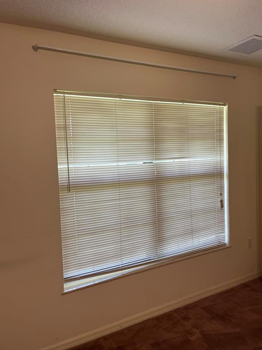 A bedroom window with horizontal blinds and a curtain rod mounted above it — 8451 SW 14th Lane, Okeechobee FL 34974, OKEECHOBEE, FL